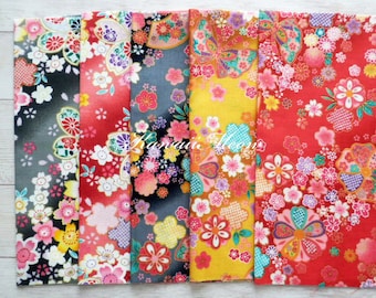 May include: A collection of colorful floral fabric panels. The fabrics feature a variety of Japanese-inspired floral patterns in shades of red, yellow, black, and gray. The designs include cherry blossoms and other stylized flowers.