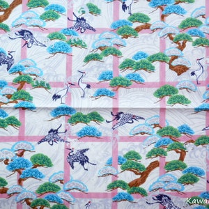 May include: White fabric with a pink grid pattern featuring a repeating design of stylised green pine trees and blue and white cranes.