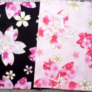 May include: Two fabric squares with a pink and white cherry blossom pattern. One square is black with white accents and the other is pink with gold accents. The pink square has the text "KawaiiMeow" in the bottom right corner.