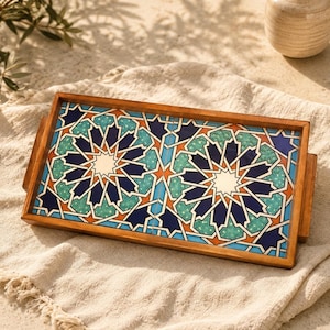 May include: A rectangular wooden serving tray featuring two inset tiles with a geometric star pattern in shades of navy blue, turquoise, and orange. The tray has a smooth, polished wood frame with integrated side handles for easy carrying.