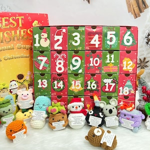 May include: A Christmas advent calendar with red and green boxes numbered 1-18. The calendar is decorated with festive images. Below are several crocheted figures, each holding a small sign with text.