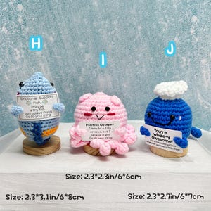 May include: Three crocheted plush toys: a blue fish, a pink octopus, and a blue whale. Each has a small sign with an inspirational message. The fish is 2.3 x 3.1 inches, the octopus is 2.3 x 2.3 inches, and the whale is 2.3 x 2.7 inches.