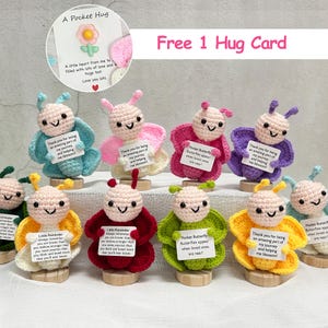 May include: A collection of handmade crochet butterfly dolls in various colors, including blue, pink, red, green, and yellow. Each doll holds a small card with a message. The image also includes a card that says "A Pocket Hug."