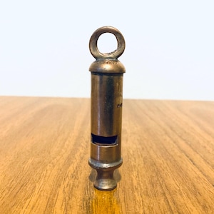 Antique brass whistle, with patent written on the top and side of the whistle. The item is in working condition