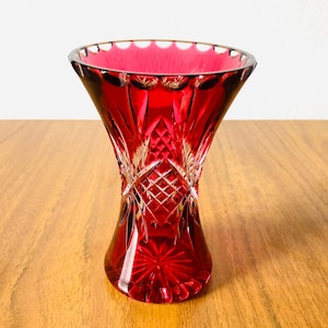 A stylish ruby red lead crystal cut mini vase with intricate cut patterns. This piece of art glass was made in Bohemia Circa 1950