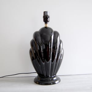May include: A black ceramic table lamp with a scalloped design. The lamp has a black cord and a black socket.