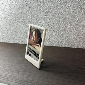 Peut inclure: Cadre photo blanc avec une photo d'une femme &agrave; l'int&eacute;rieur. Le cadre a un support au dos.
