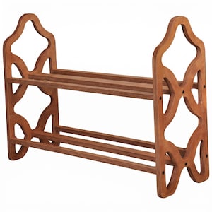 May include: A wooden shoe rack with two shelves and decorative side cutouts. The rack is made of light brown wood and has a simple, functional design. The shoe rack is designed to hold multiple pairs of shoes.