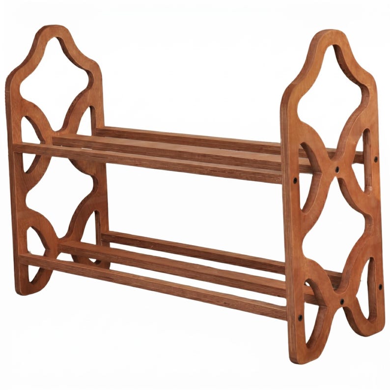 May include: A wooden shoe rack with two shelves and decorative side cutouts. The rack is made of light brown wood and has a simple, functional design. The shoe rack is designed to hold multiple pairs of shoes.