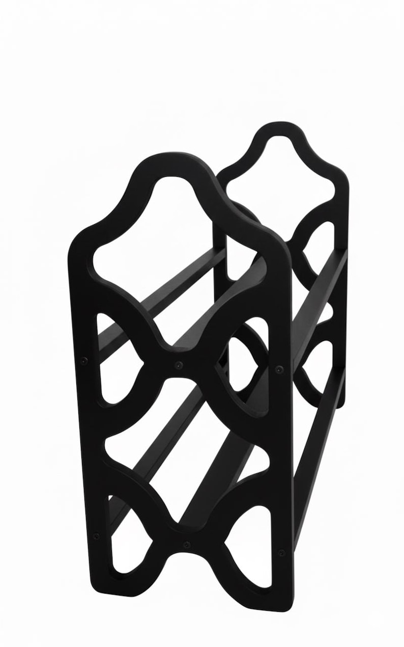 May include: Black wooden wine rack with a decorative, openwork design. The rack has a curved top and holds multiple bottles. The design features geometric cutouts and horizontal supports, suitable for home decor.
