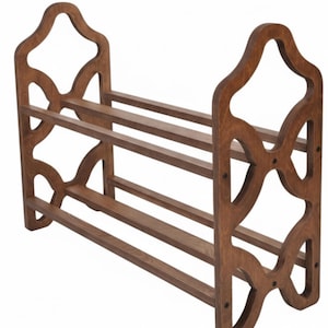 May include: A wooden shoe rack with a dark brown finish. The rack has three shelves and decorative side panels with an open, geometric design. The rack is approximately 30 inches wide, 12 inches deep, and 24 inches tall.