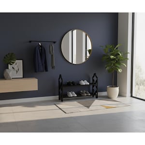 May include: A modern entryway with a dark blue wall, featuring a round mirror, a black shoe rack with shoes, a coat rack with a navy blazer and scarf, and a decorative plant. A geometric rug and a wooden console table complete the decor.