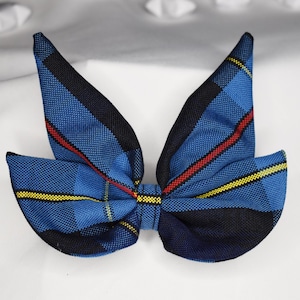 May include: A blue, yellow, and red plaid bow tie. The bow tie is made of fabric and has a classic shape.