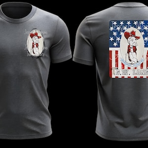 May include: A charcoal gray t-shirt featuring a cartoon cowboy design on the front and back. The front design is an oval portrait of a cowboy. The back design is a patriotic graphic with the text "G.W. LONG".