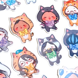 May include: A collection of colorful stickers featuring cartoon characters dressed in cat costumes. Each sticker has a unique color scheme, including orange, gray, and white, with bows and cat ears. The stickers are designed with a cute, playful aesthetic.