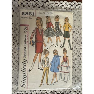 May include: Vintage Simplicity doll pattern 5861, featuring illustrations of various doll outfits. The pattern includes a red dress, a checkered skirt, a yellow top with a green skirt, and other stylish designs. The pattern is marked "Doll-One Size".
