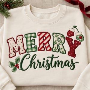 Pode incluir: Uma camisola de gola redonda cor de creme com o texto MERRY em letras grandes e estampadas com padrões vermelhos, verdes e brancos, e a palavra Christmas em letra cursiva verde-escura com um gráfico de pinheiro e bagas.