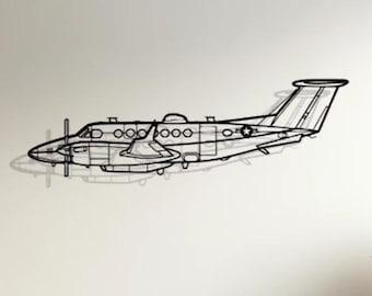 May include: A black metal airplane wall sculpture with a white background. The airplane is in flight and has a propeller on the front. The sculpture is hanging on a white wall above a white couch with beige pillows.