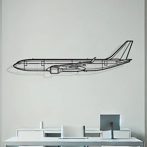 May include: A black metal airplane outline wall decor in a modern office setting. The airplane is mounted on a white wall above a white desk with a chair.
