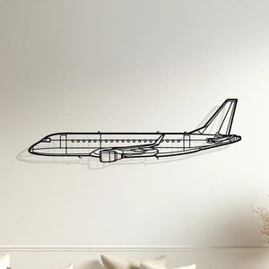 Può includere: Un decoro da parete aereo in metallo nero in un ambiente da soggiorno. L'aereo è montato su una parete bianca sopra un divano bianco con cuscini beige. Il divano è di fronte a un tavolo di legno con un vaso di fiori secchi.