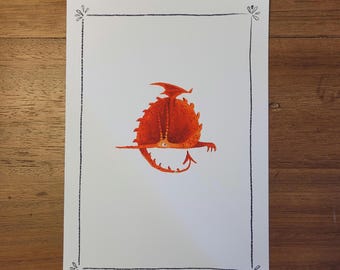 May include: A whimsical illustration of a red dragon with a spiky back, a long tail, and a small wing. The dragon is centered on a white paper with a black border and decorative corner elements. The artwork is set against a wooden background.