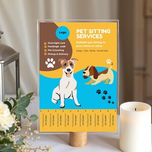 May include: A clear acrylic sign with a wooden base displays "PET SITTING SERVICES" with illustrations of dogs and paw prints. The sign includes text about overnight care, feeding, grooming, and pickup & delivery services. The background is yellow, brown, and blue.