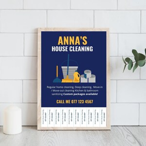 May include: A framed print with a navy blue background and the text "ANNA'S HOUSE CLEANING" in yellow. The image includes cleaning supplies and the phone number 077 123 4567. Services include regular, deep, and move-out cleaning.