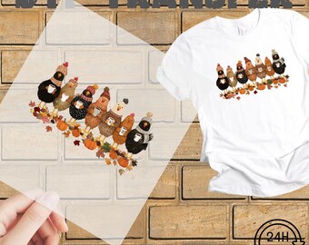 May include: White t-shirt with a fall-themed graphic of chickens wearing hats and holding coffee cups. The image also shows a ready-to-press transfer sheet with the same design, pumpkins, and fall leaves. The words "DTF TRANSFER" and "READY TO PRESS" are visible.