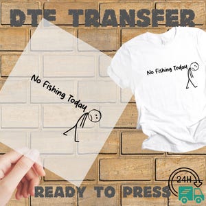 May include: A white t-shirt with the text "No Fishing Today" and a stick figure illustration. A clear transfer sheet with the same design is held in front of a brick wall. The words "DTE TRANSFER" and "READY TO PRESS" are also visible.
