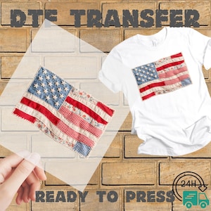 May include: White t-shirt with a sewn-on American flag design. The flag features red and white stripes and a blue field with white stars. The image also shows a DTE transfer and the words "READY TO PRESS".