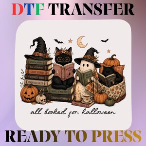 May include: A DTF transfer sheet featuring the text DTF TRANSFER and READY TO PRESS. The central graphic shows two black cats and a ghost wearing witch hats, reading books atop a stack of volumes labeled with spooky titles, pumpkins, and a skull.