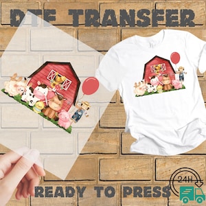 May include: White t-shirt with a colorful farm animal graphic. The design includes a red barn, sheep, cows, pigs, a farmer, and a red balloon. The words "READY TO PRESS" are printed at the bottom.