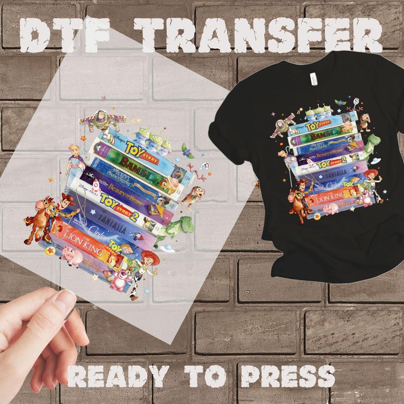 May include: Black t-shirt with a colorful graphic of stacked VHS tapes featuring characters from Toy Story, Bambi, and The Lion King. A DTF transfer and the text "READY TO PRESS" are also visible.
