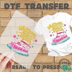 May include: A white t-shirt and a transparent DTF transfer sheet both featuring a graphic of a pink pontoon boat on blue water with yellow cursive text that reads whatever floats your and colorful stars surrounding the boat design.