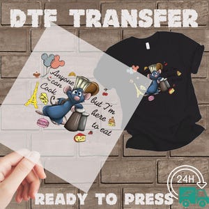 May include: DTF transfer featuring a cartoon rat chef with the text "Anyone can cook but I'm here to eat." The design includes the Eiffel Tower, cheese, and macarons. The image also shows a black t-shirt with the same design.