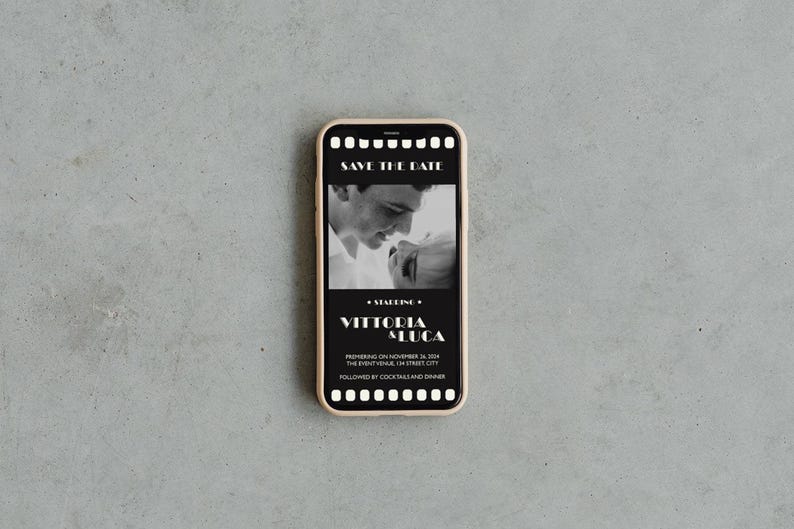 May include: A black and white photo of a couple on a smartphone screen. The screen has a film strip border and the text "Save the Date" at the top. The text "Vittorio & Luca" is below the photo. The text "Premiere on November 24, 2024" is below the names. The text "The Event Venue: 14 Street City" is below the date. The text "Followed by Cocktails and Dinner" is at the bottom of the screen.