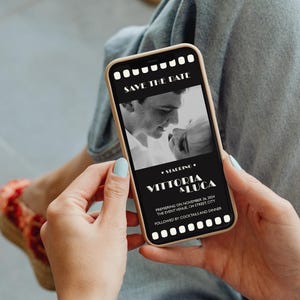 May include: A black and white photo of a couple on a smartphone screen. The screen displays a save the date announcement for Vittoria & Luca, with the date November 28, 2024, and the event venue, 124 Street City. The announcement is framed with a film strip border.
