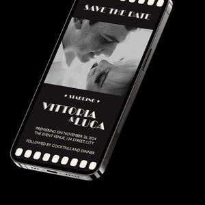 May include: A black and white photo of a couple on a smartphone screen with the text "SAVE THE DATE" at the top and "★STARRING★ VITTORIA & LUCA" in the middle. The text below reads "PREMIERING ON NOVEMBER 26, 2024 THE EVENT VENUE, 134 STREET, CITY FOLLOWED BY COCKTAILS AND DINNER".
