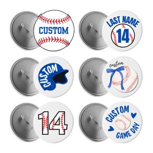 May include: A collection of baseball-themed buttons with various designs. Some buttons feature a baseball with the word "CUSTOM" in blue. Others display a baseball with a blue ribbon, a baseball helmet, or the number "14". The buttons are white with red and blue accents.
