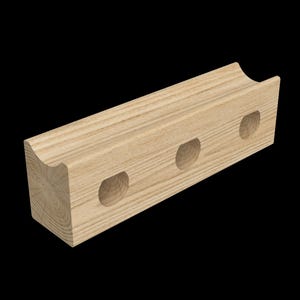 May include: A light-colored wooden wine bottle holder with a curved top and three circular cutouts. The holder is rectangular and made of natural wood, showcasing the grain.