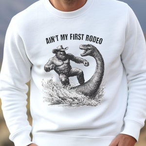 Western Bigfoot Meme Sweatshirt, Funny Bigfoot Cowboy Nessie Pullover, Ain&#39;t My First Rodeo Shirt, Loch Ness Monster Sasquatch Design Gift