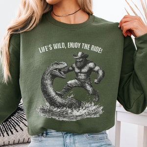 Funny Bigfoot Cowboy Sweatshirt, Western Bigfoot Meme Pullover, Life&#39;s Wild Enjoy the Ride Shirt, Quirky Loch Ness Monster Sasquatch Design