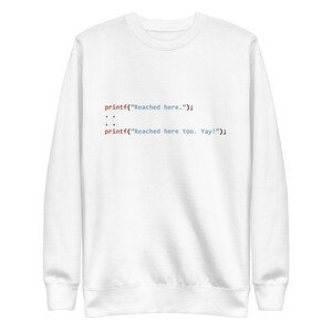 May include: White sweatshirt with a code snippet printed on the front. The code reads: "printf("Reached here."); :: printf("Reached here too. Yay!");"