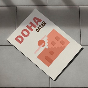 Puede incluir: Un póster beige con el texto "DOHA QATAR" en letras marrones. El póster presenta una ilustración estilizada de un edificio rosa con un sol rosa y nubes rosas.