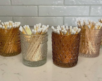 May include: Six amber glass jars with embossed designs, filled with white-tipped wooden matches.