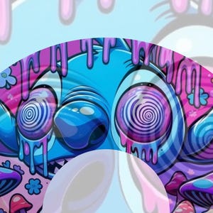 Puede incluir: Una pegatina gráfica circular que presenta un personaje alienígena azul con ojos grandes que contienen patrones de espiral. El diseño incluye líquido rosa goteando desde la parte superior, rodeado de setas moradas y azules y pequeñas flores.