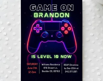May include: Black invitation card with a neon-style game controller graphic. Text reads "GAME ON BRANDON" and "IS LEVEL 10 NOW". Includes event details: Saturday, June 17th, 12-2pm, Williams Residence, Boulder CO, RSVP by Sept 20th.