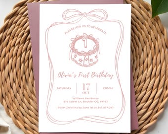 May include: A pink and white birthday invitation with a bow design at the top. The invitation reads "Olivia's First Birthday" and includes the date, time, and location. The invitation is on a woven background.