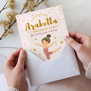 Puede incluir: Una invitación de fiesta de cumpleaños rosa y dorada con una ilustración de dibujos animados de una niña haciendo una pose de gimnasia. El texto de la invitación dice: "Únete a nosotros para celebrar Arabella 7th Birthday Party flip, tumble, jump and play".