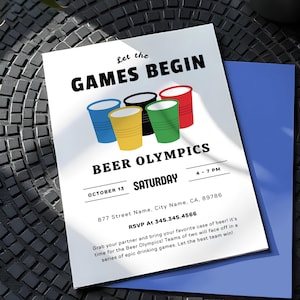 Pode incluir: Um cartão de convite branco com o texto "Let the GAMES BEGIN" e "BEER OLYMPICS". O cartão apresenta ilustrações coloridas de copos de cerveja. Inclui detalhes do evento: data, hora, local e informações de RSVP. Um envelope azul é visível.